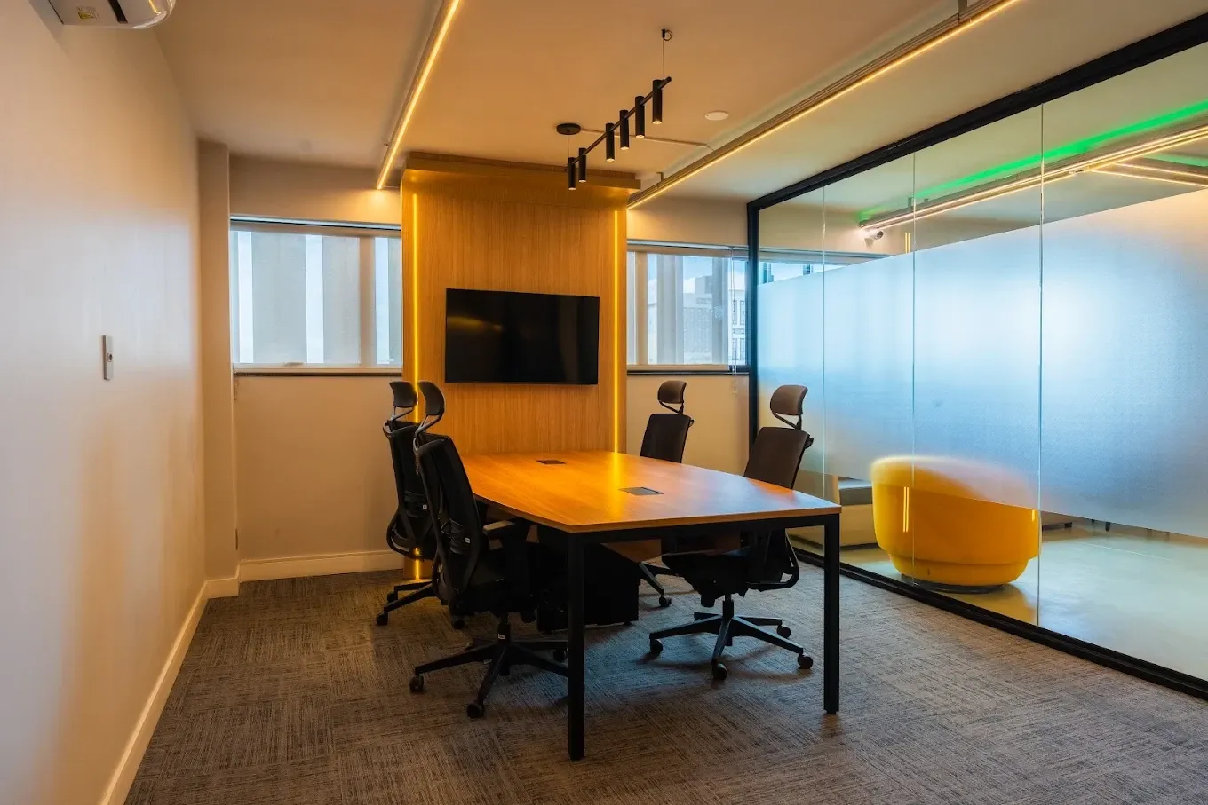 Sala de reunião da sede da Novvacar, com mesa, cadeiras e televisão